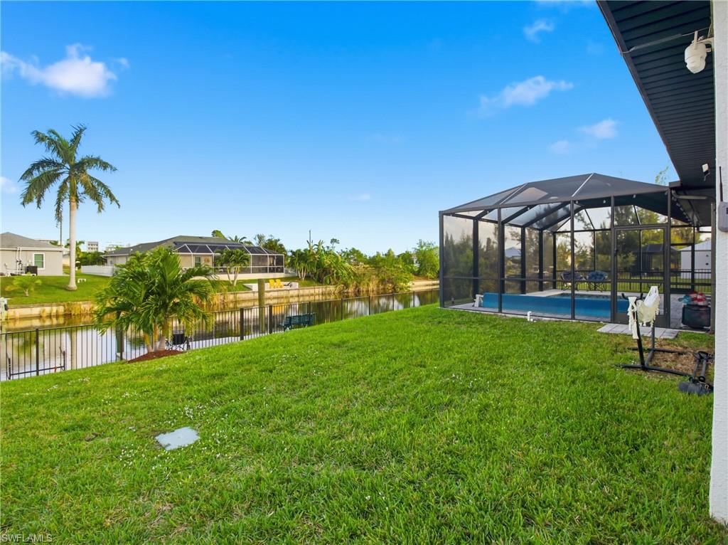 View of yard featuring a screened enclosure, a lanai, and a water view