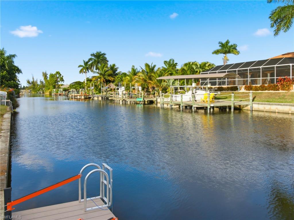 Dock area featuring a sunroom, a water view, and boat lift