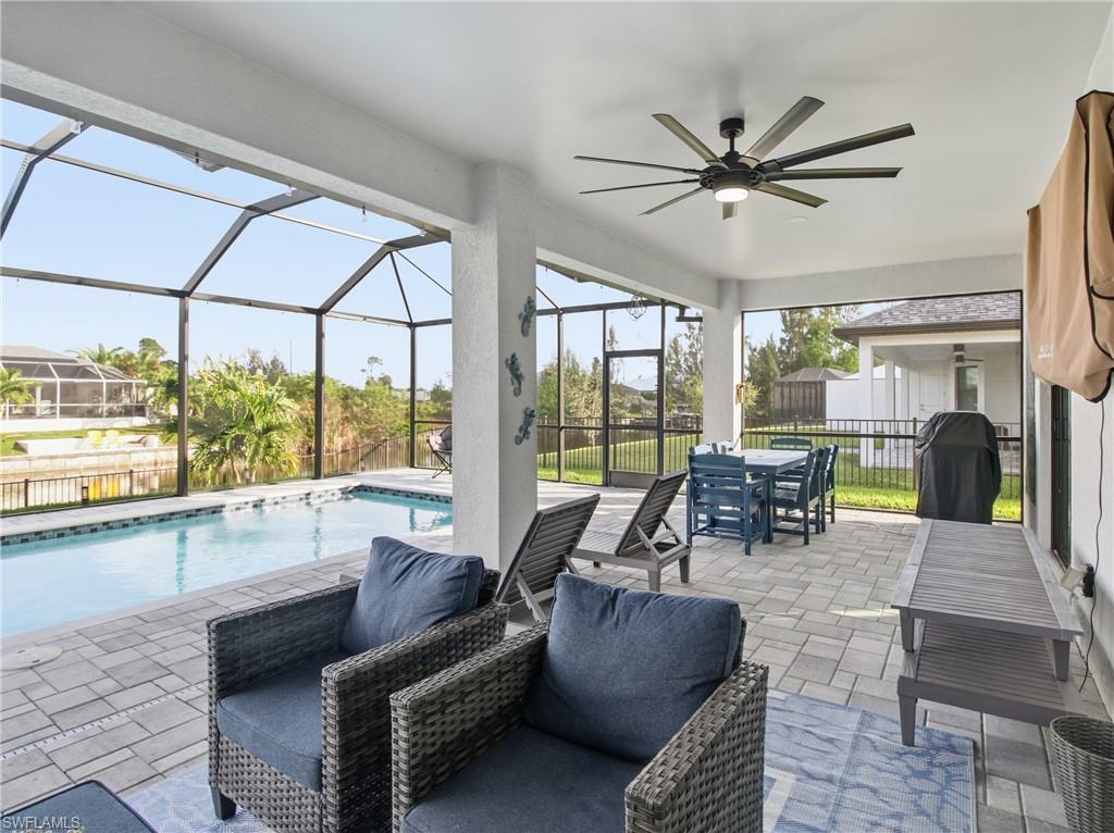 Fenced backyard featuring a lanai, a patio area, a ceiling fan, and a lounging area