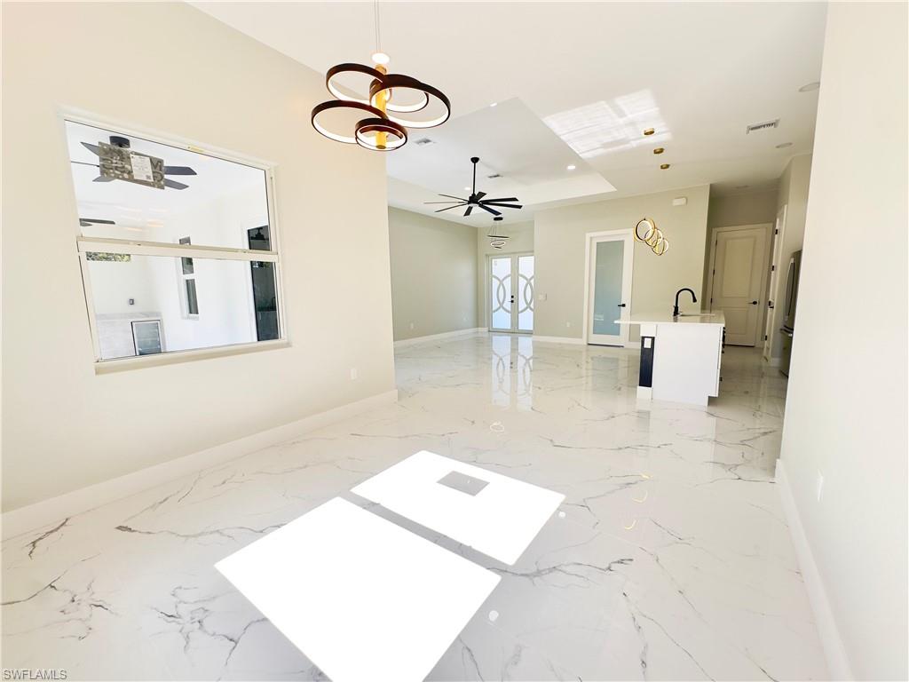 Unfurnished room with light marble finish flooring and french doors