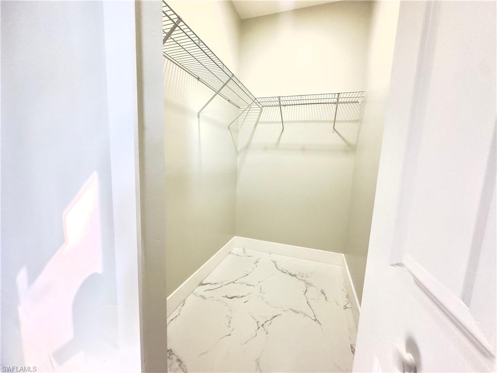 Spacious closet with marble look tile flooring