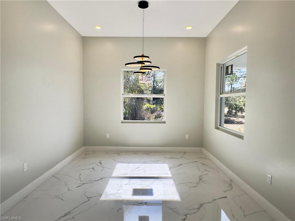 Unfurnished room featuring marble tiled flooring and recessed lighting