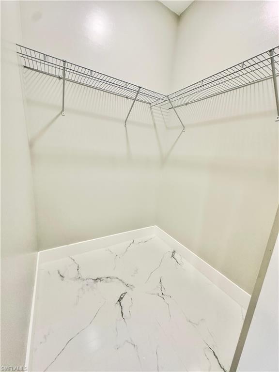Walk in closet with marble finish floors