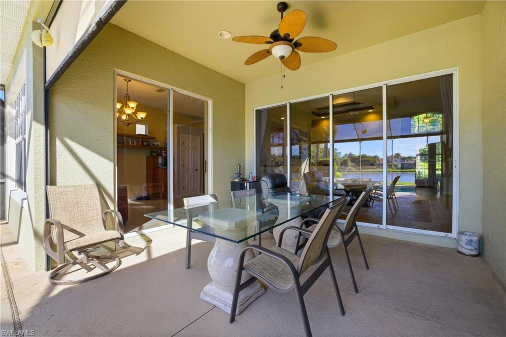 View of patio / terrace featuring a ceiling fan, a water view, and outdoor dining space