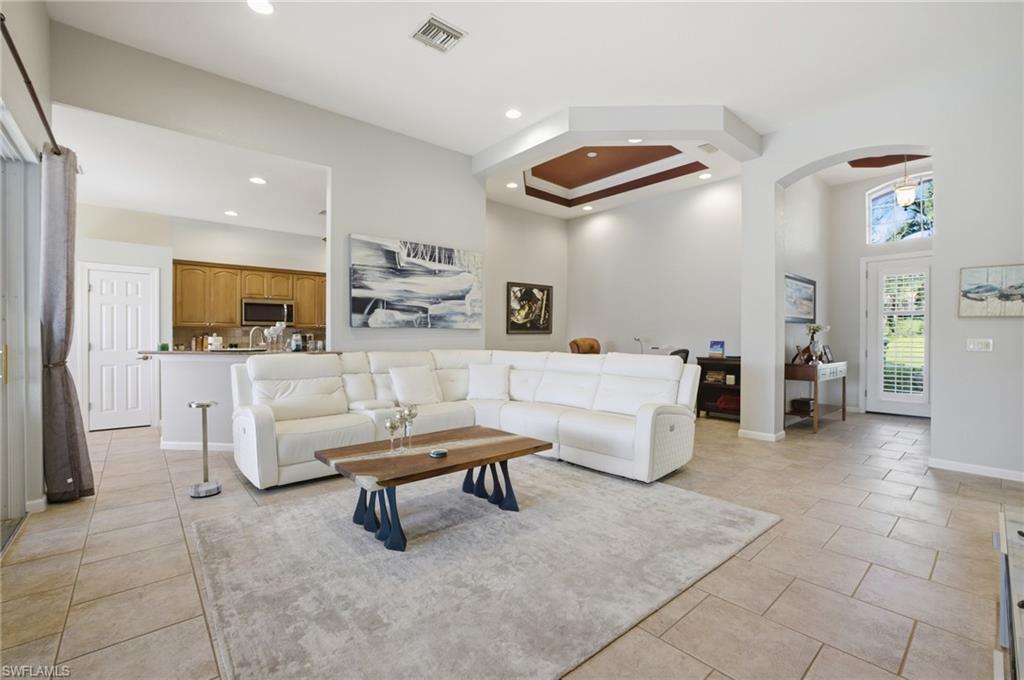 Living room with recessed lighting, arched walkways, and a high ceiling