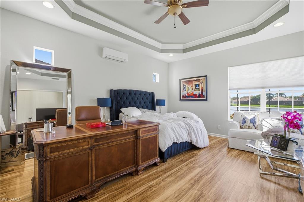 Bedroom with an office area, light wood-style floors, recessed lighting, crown molding, and a ceiling fan