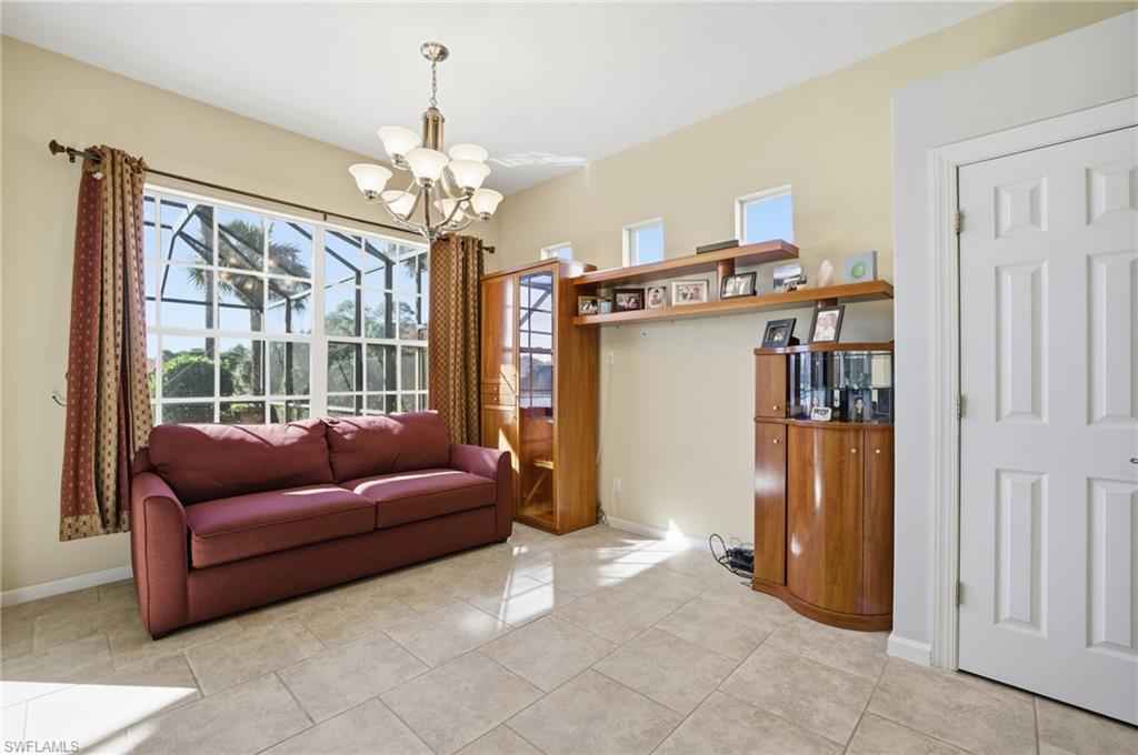 Living room featuring plenty of natural light, light tile patterned floors, and a chandelier