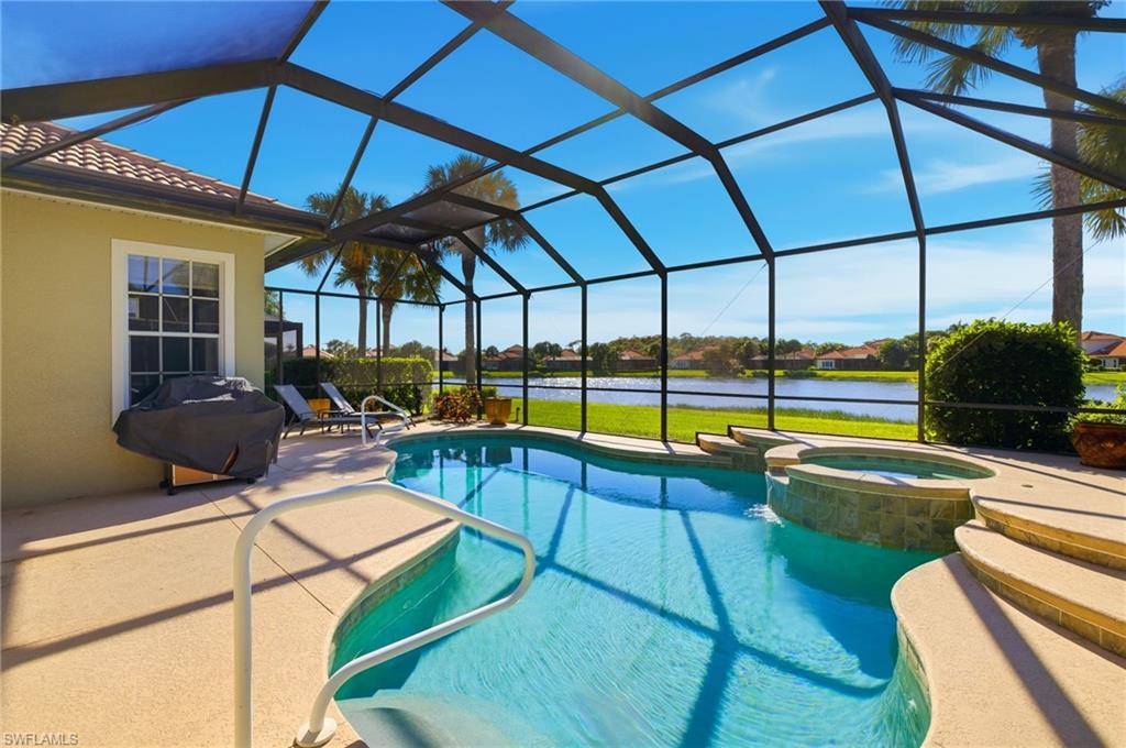 View of pool featuring a sunroom, a water view, a patio area, and glass enclosure