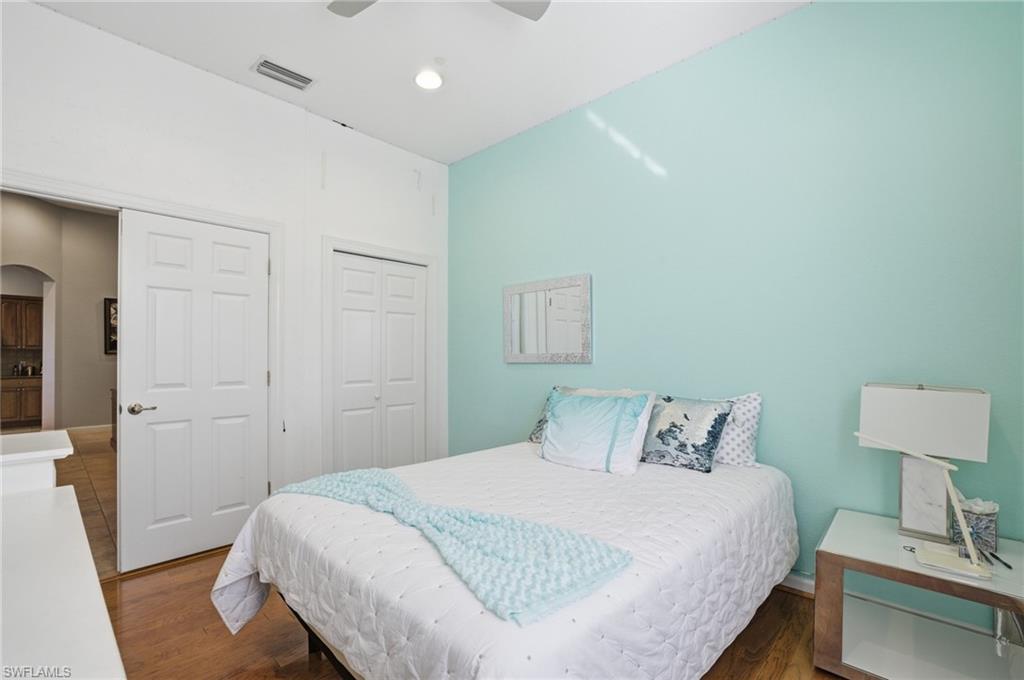 Bedroom featuring wood finished floors, a closet, a ceiling fan, and arched walkways