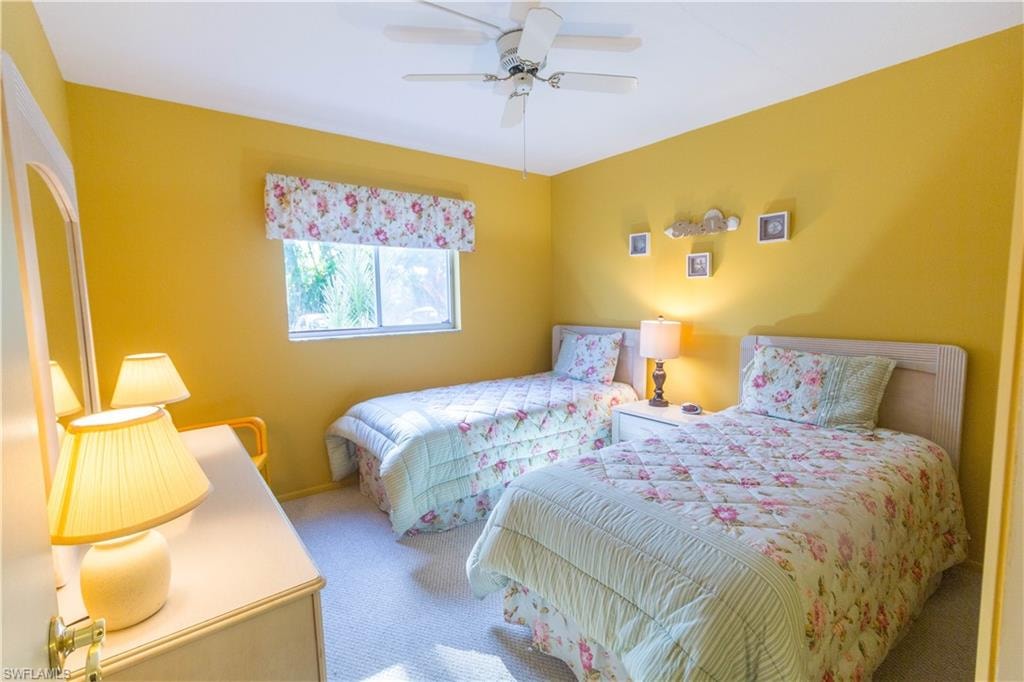 Carpeted bedroom featuring a ceiling fan