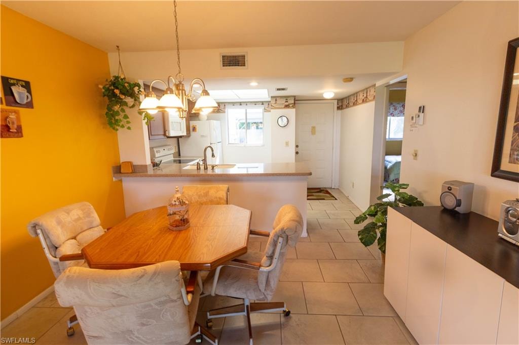 Dining room featuring a chandelier and light tile patterned floors