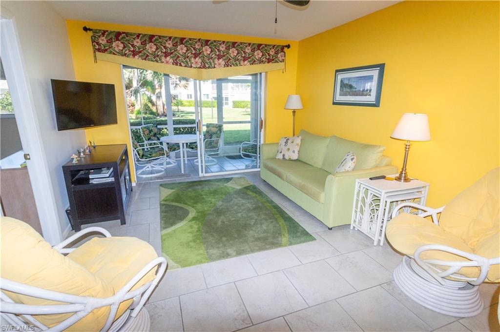 Tiled living room featuring a ceiling fan and plenty of natural light
