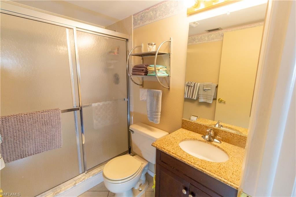 Full bath with a shower stall, vanity, and tile patterned floors