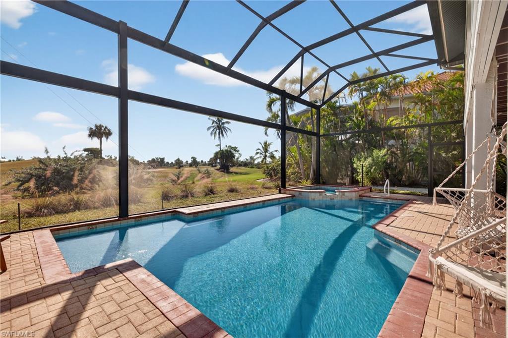 View of swimming pool with a sunroom, a lanai, a patio area, and a pool with connected hot tub
