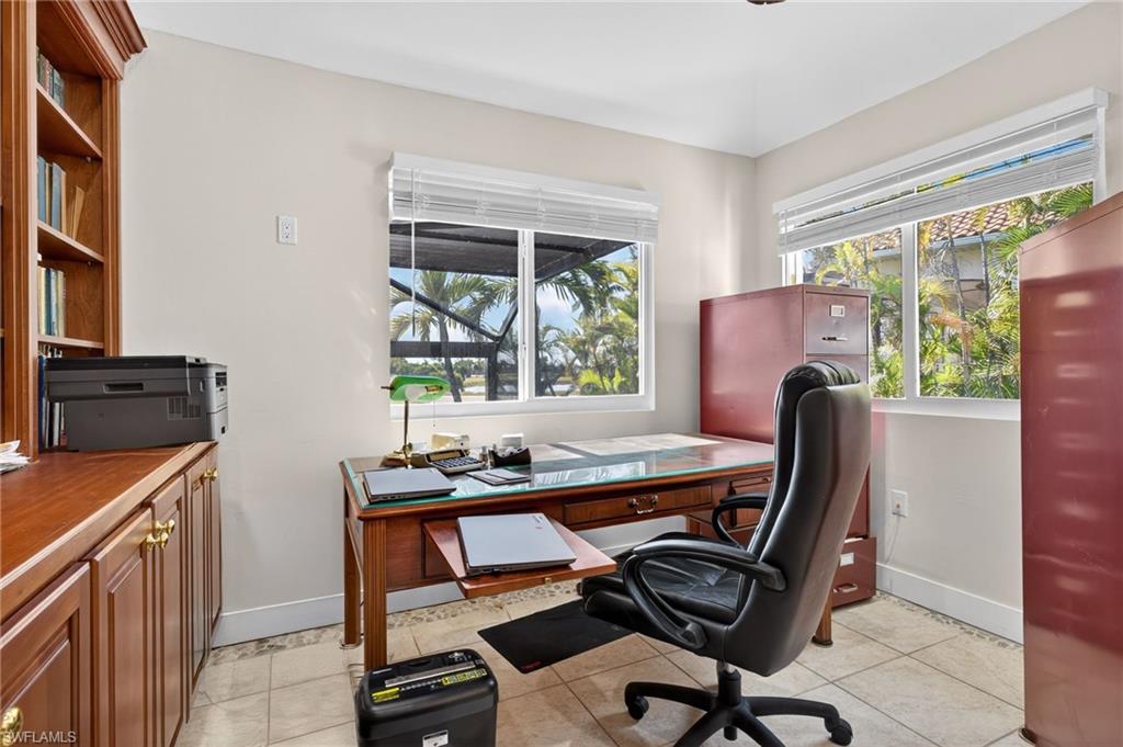 Office with light tile patterned flooring and plenty of natural light