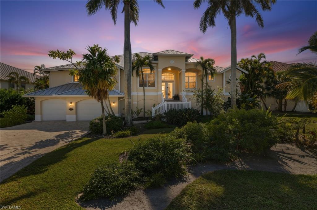 Mediterranean / spanish-style house featuring decorative driveway, stucco siding, a standing seam roof, a metal roof, and a garage
