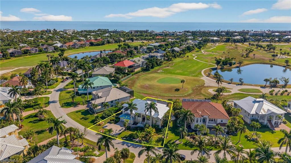 Aerial perspective of suburban area featuring a nearby body of water, a local golf course, and property parcel outlined