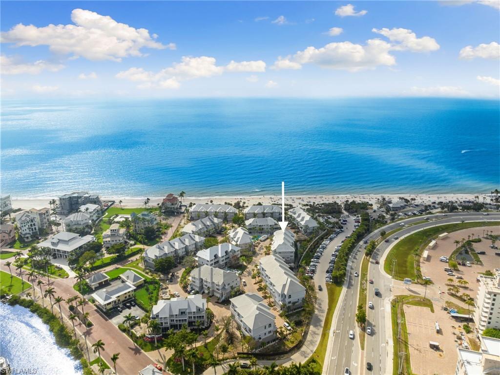 Aerial overview of property's location featuring waterfront with a beach