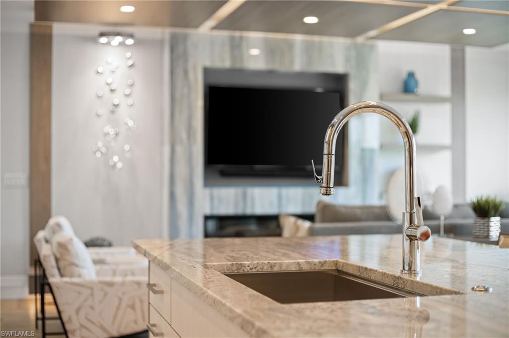 Kitchen view of light stone countertops and recessed lighting