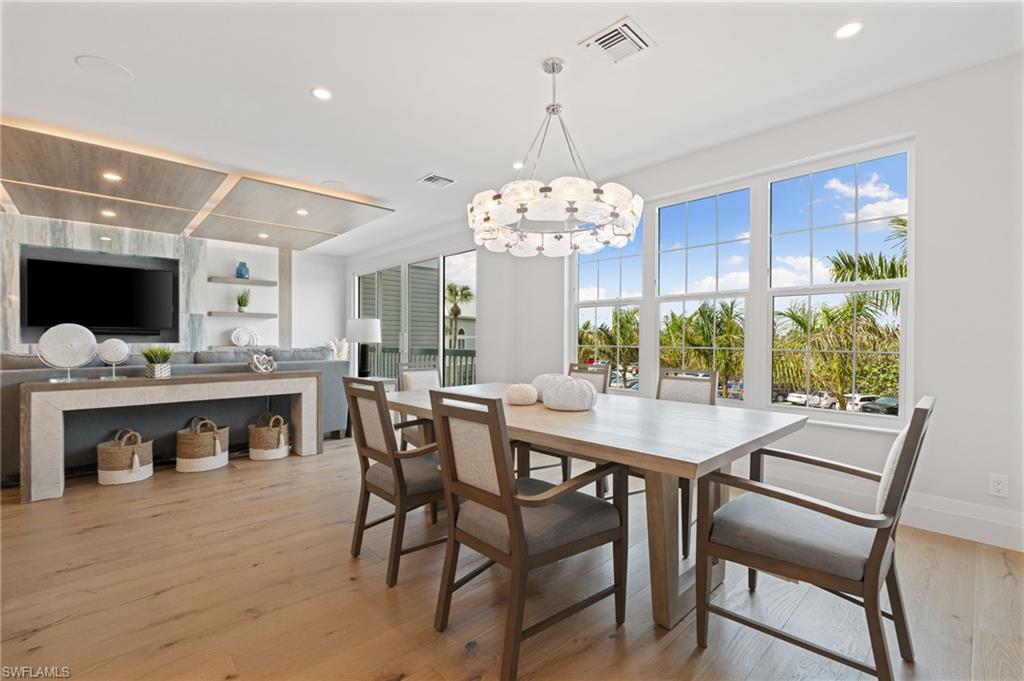 Dining space featuring light wood finished floors, recessed lighting, built in features, and a chandelier
