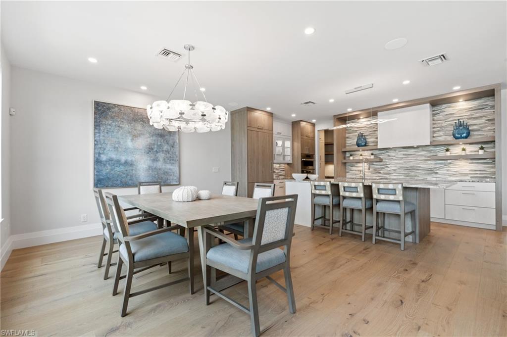 Dining room with a chandelier, light wood-type flooring, and recessed lighting
