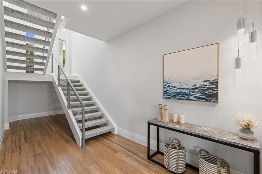 Stairway with baseboards and wood finished floors