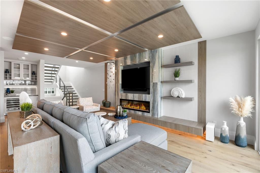Living area with stairway, light wood-style flooring, wood ceiling, recessed lighting, and a tile fireplace