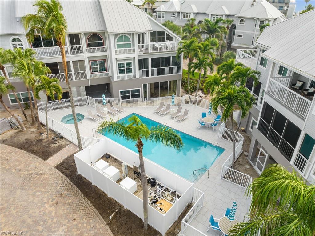 Community pool with a patio area and a fenced backyard