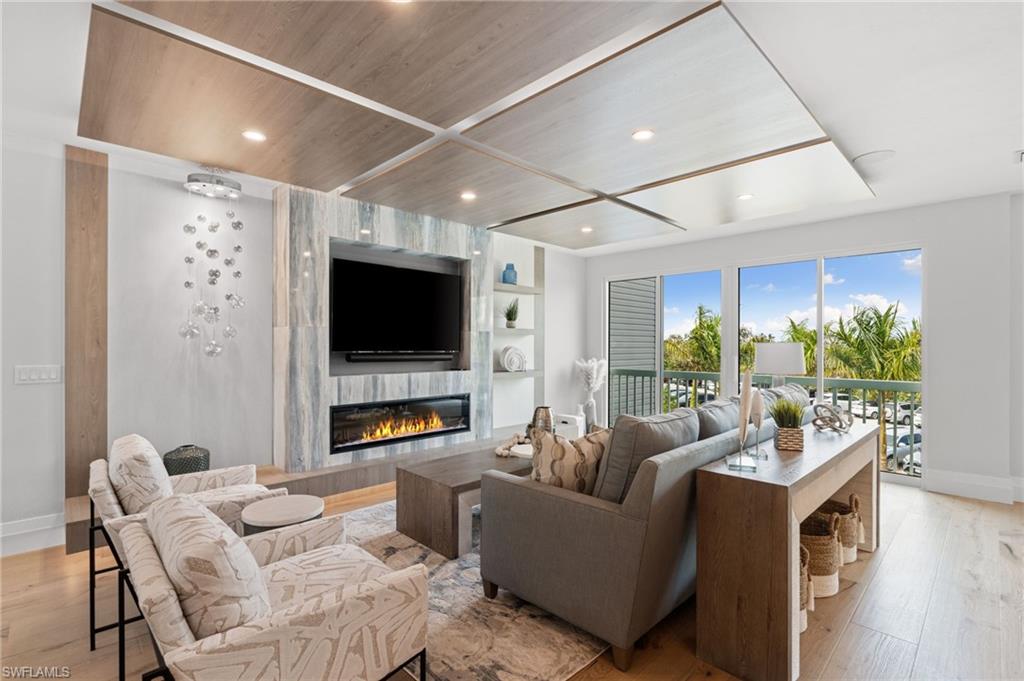Living area with light wood-style floors, a fireplace, recessed lighting, and built in shelves