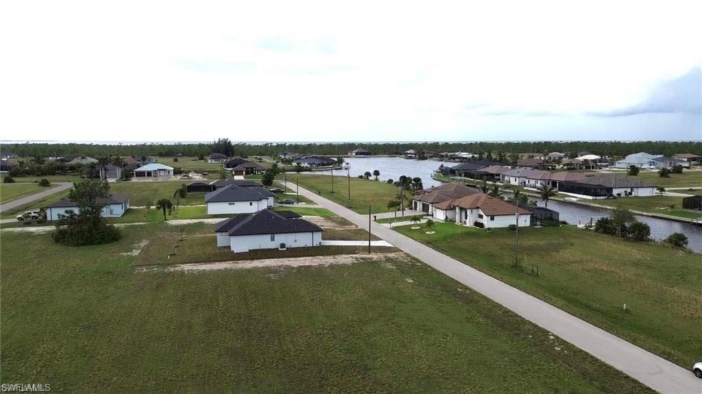Aerial perspective of suburban area featuring a nearby body of water