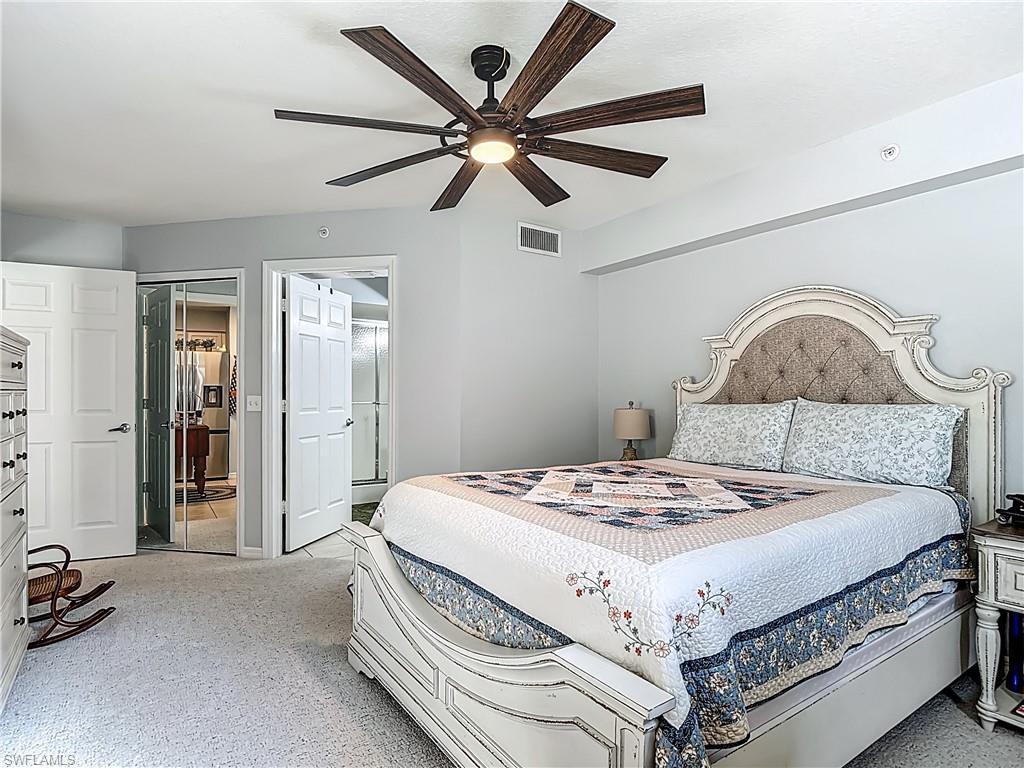 Carpeted bedroom featuring ceiling fan and high end fridge