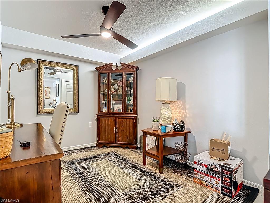 Office with a textured ceiling and carpet
