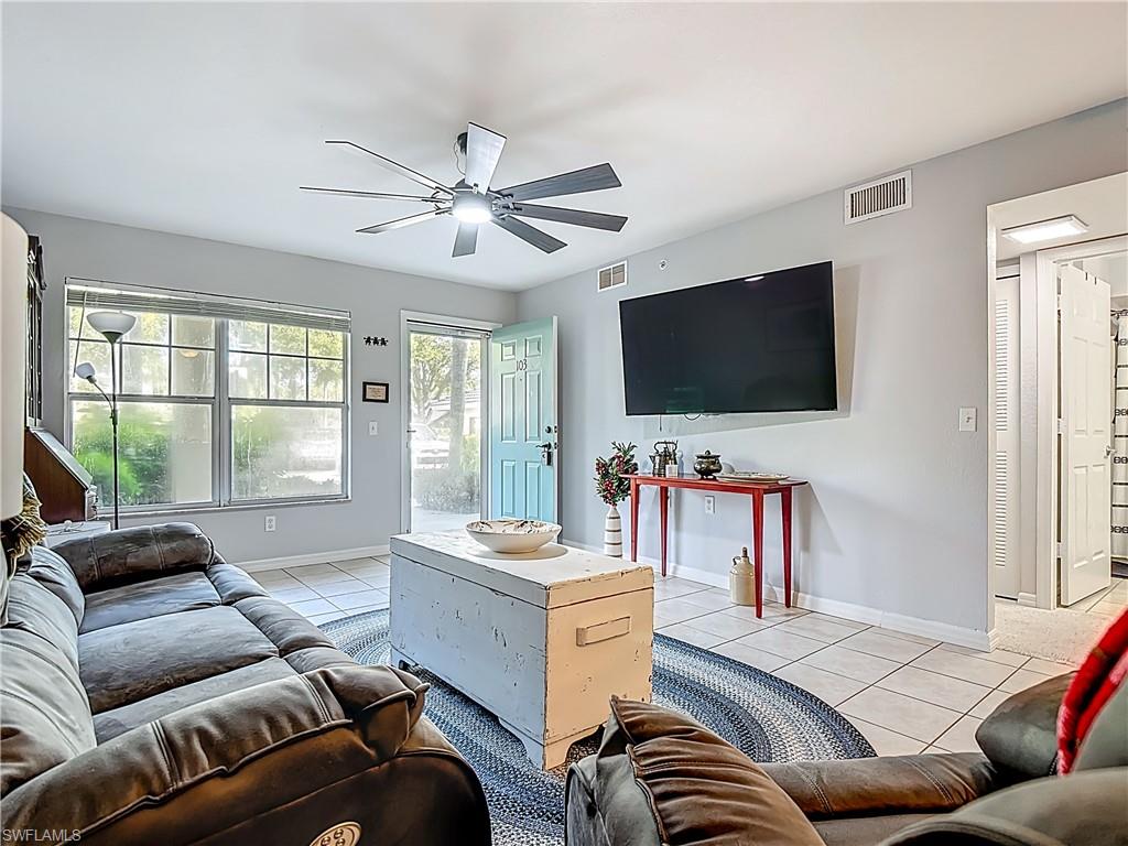 Living room featuring light tile patterned flooring and ceiling fan