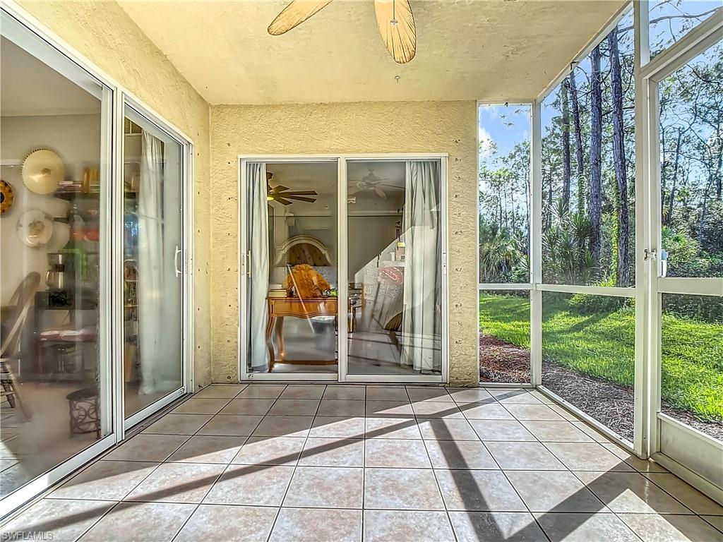 Unfurnished sunroom featuring a ceiling fan and a patio