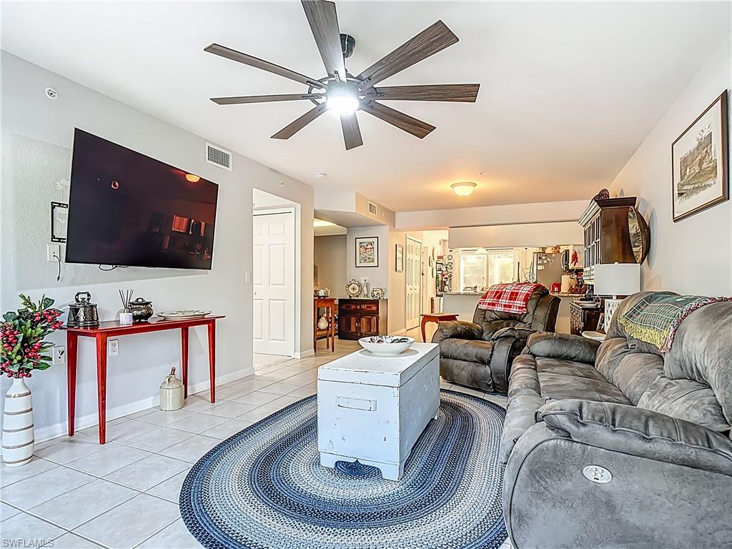 Living area with light tile patterned floors and ceiling fan