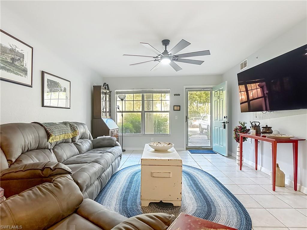 Living room with tile patterned flooring and ceiling fan
