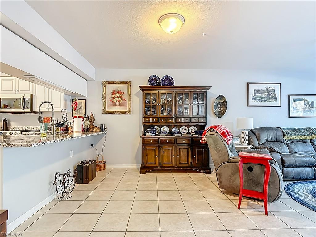Living area with light tile patterned floors and a textured ceiling