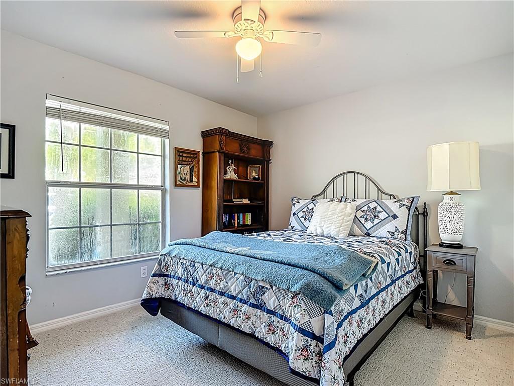 Bedroom with ceiling fan and light carpet