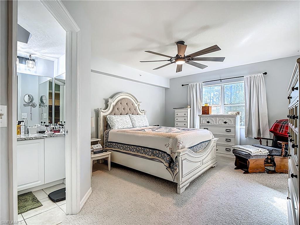 Bedroom with ceiling fan and light carpet