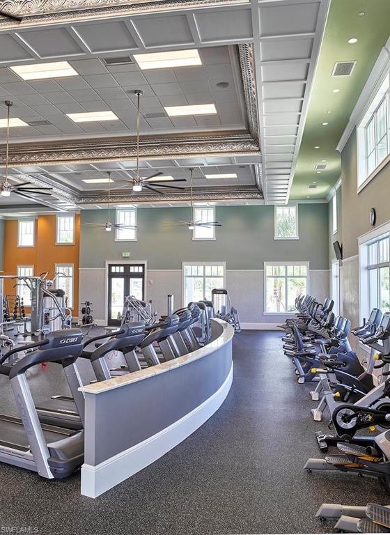 Workout area with ornamental molding and a wainscoted wall