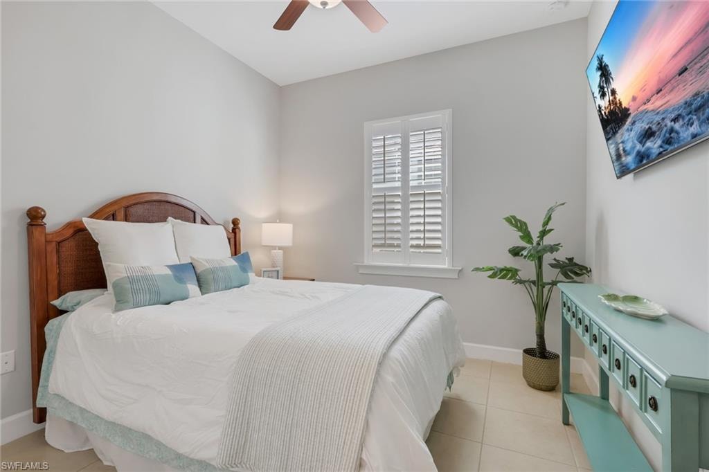 Bedroom with light tile patterned floors and ceiling fan
