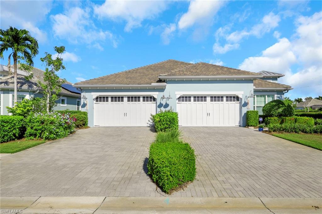 View of front of property featuring stucco siding, decorative driveway, and a garage