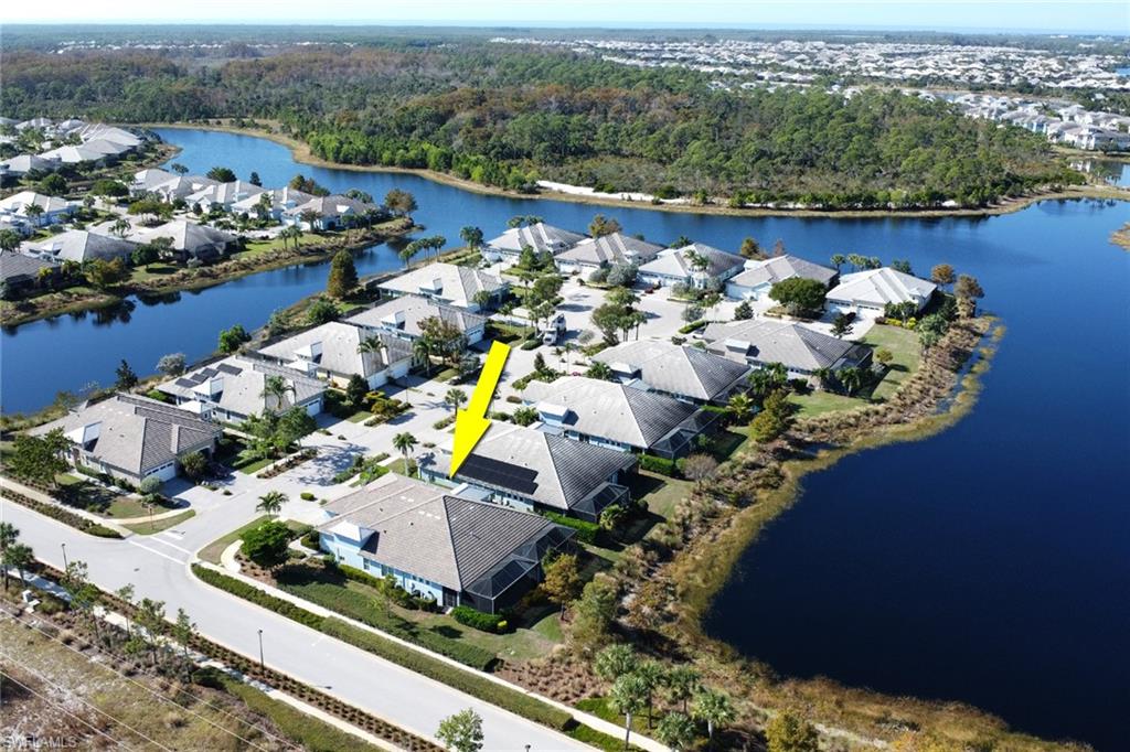 Aerial view of residential area featuring a nearby body of water