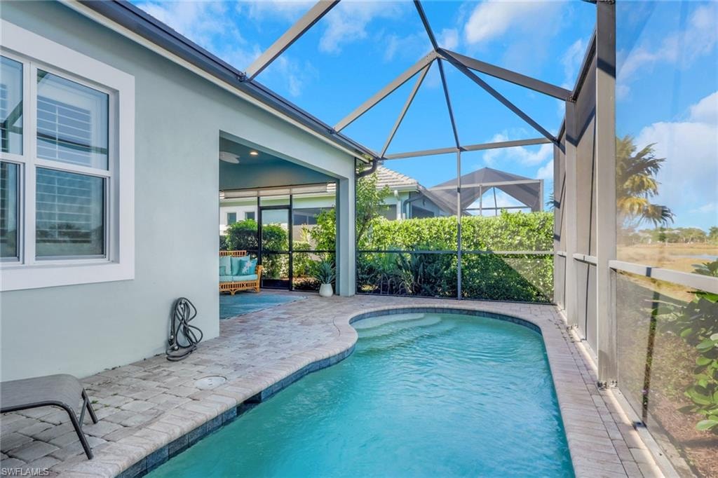 Outdoor pool with a patio, a lanai, and a sunroom