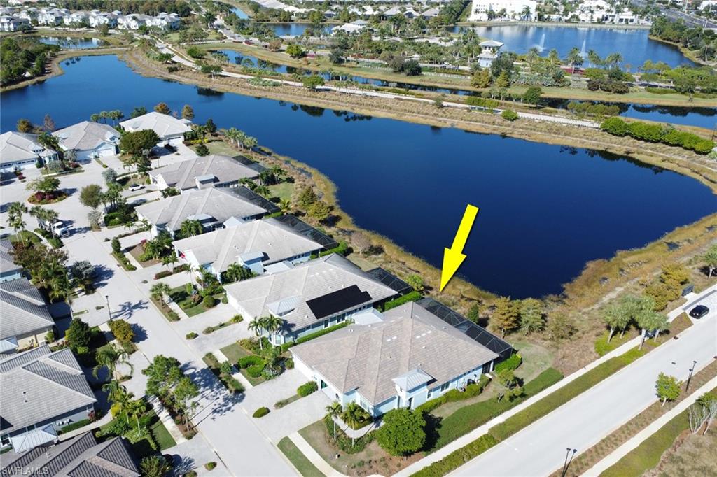Aerial view of property and surrounding area featuring a large body of water and nearby suburban area