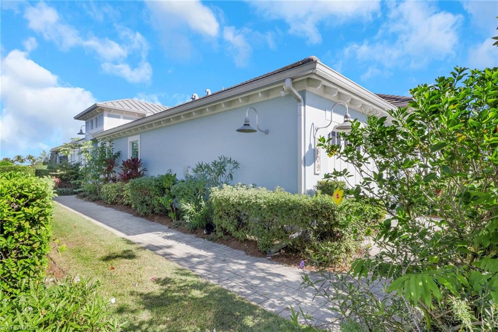 View of property exterior with stucco siding and a yard
