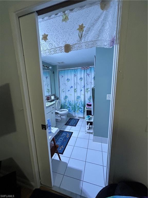 Bathroom featuring vanity, light tile patterned flooring, and shower / tub combo with curtain
