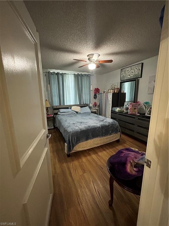 Bedroom featuring wood finished floors, ceiling fan, and a textured ceiling