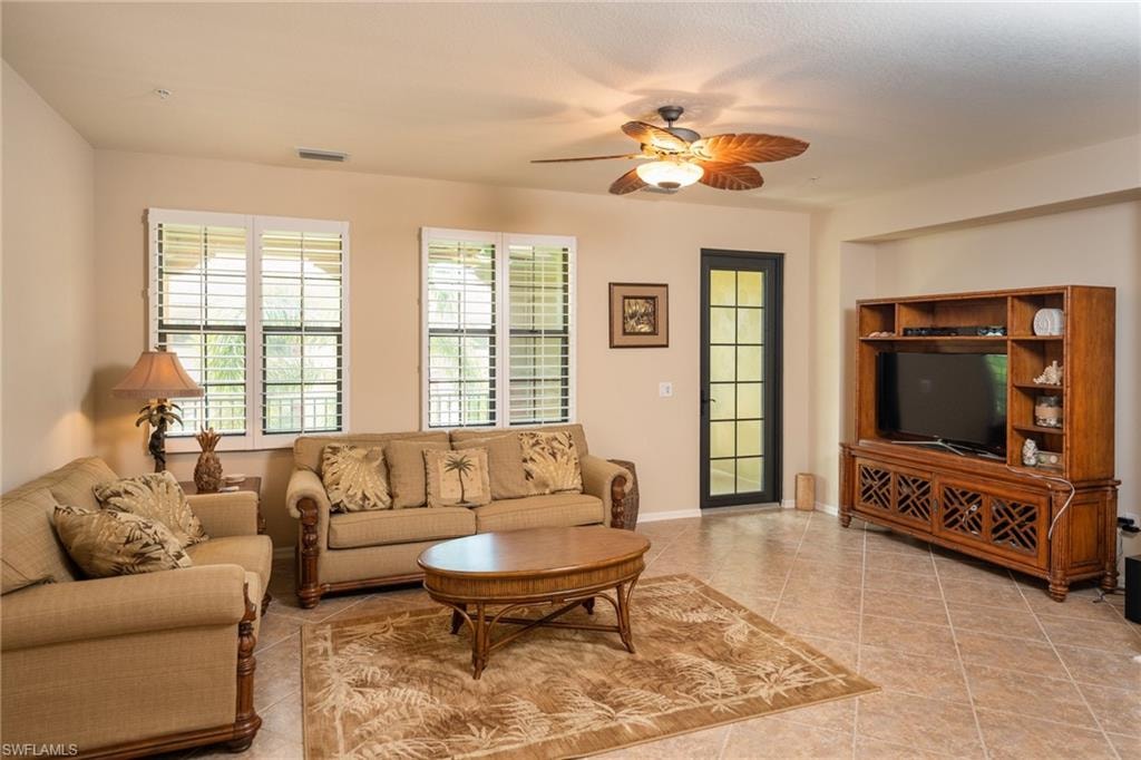 Living area with a ceiling fan and tile patterned floors