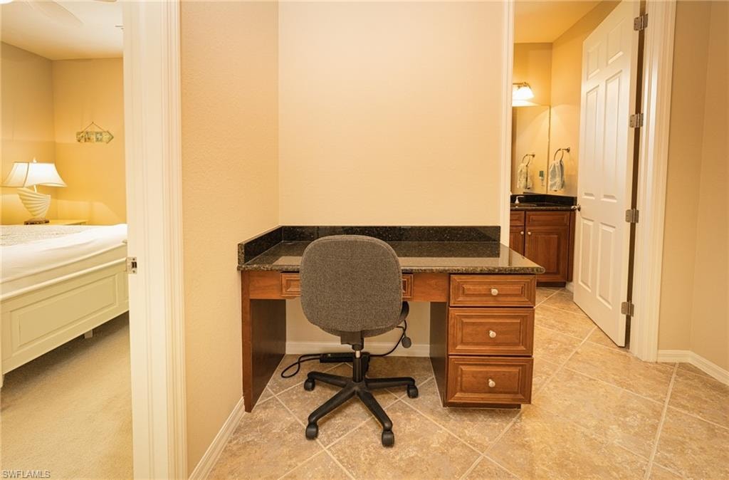 Office featuring built in desk and light tile patterned floors